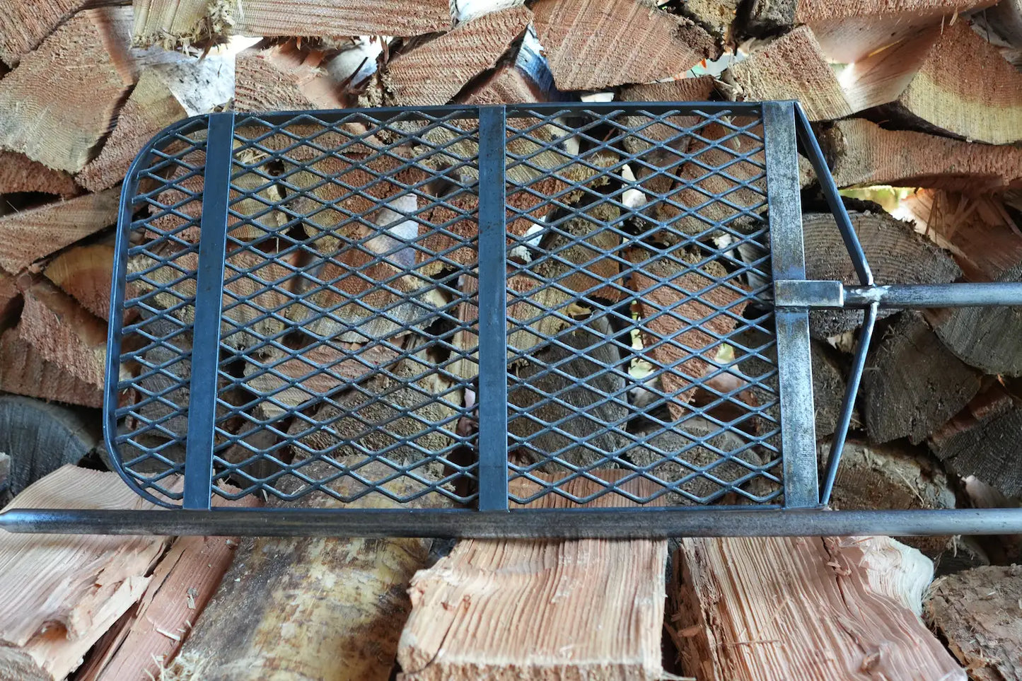 ANVIL Grill bottom with post on firewood pile