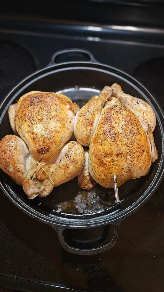Two roast chickens in cast iron roaster