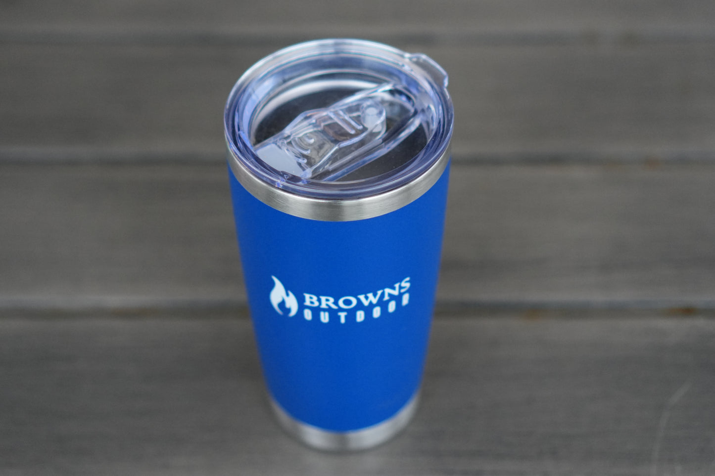 16 oz insulated tumbler on log by campfire at dusk