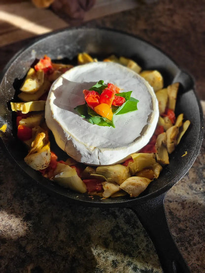 Cast fry pan with brie cheese and artichoke hearts