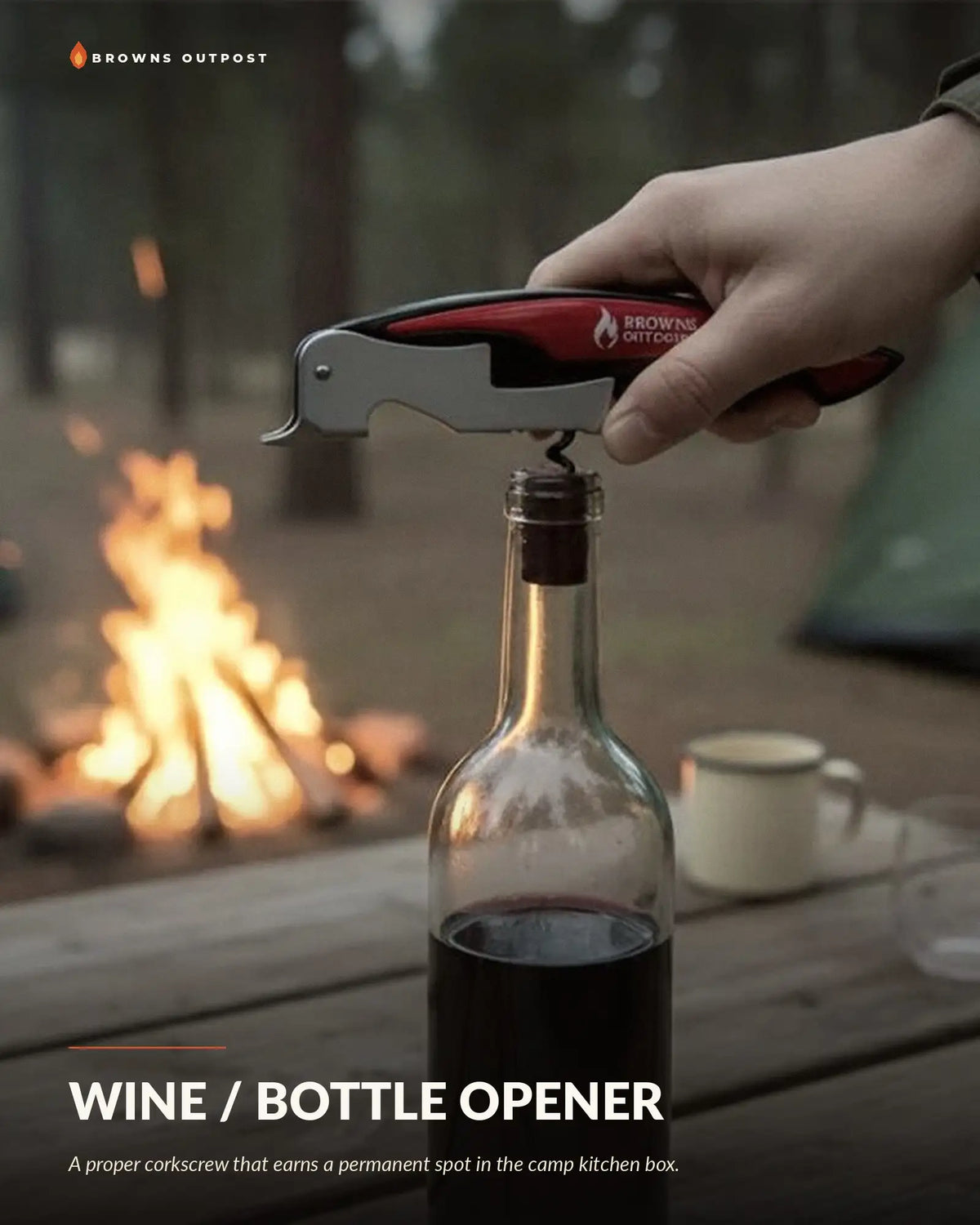 Browns Outpost wine corkscrew and bottle opener being used to open a bottle of red wine at a campsite. Text at the top reads 'Browns Outpost' and the bottom reads 'WINE / BOTTLE OPENER' with a tagline reading 'A proper corkscrew that earns a permanent spot in the camp kitchen box.'